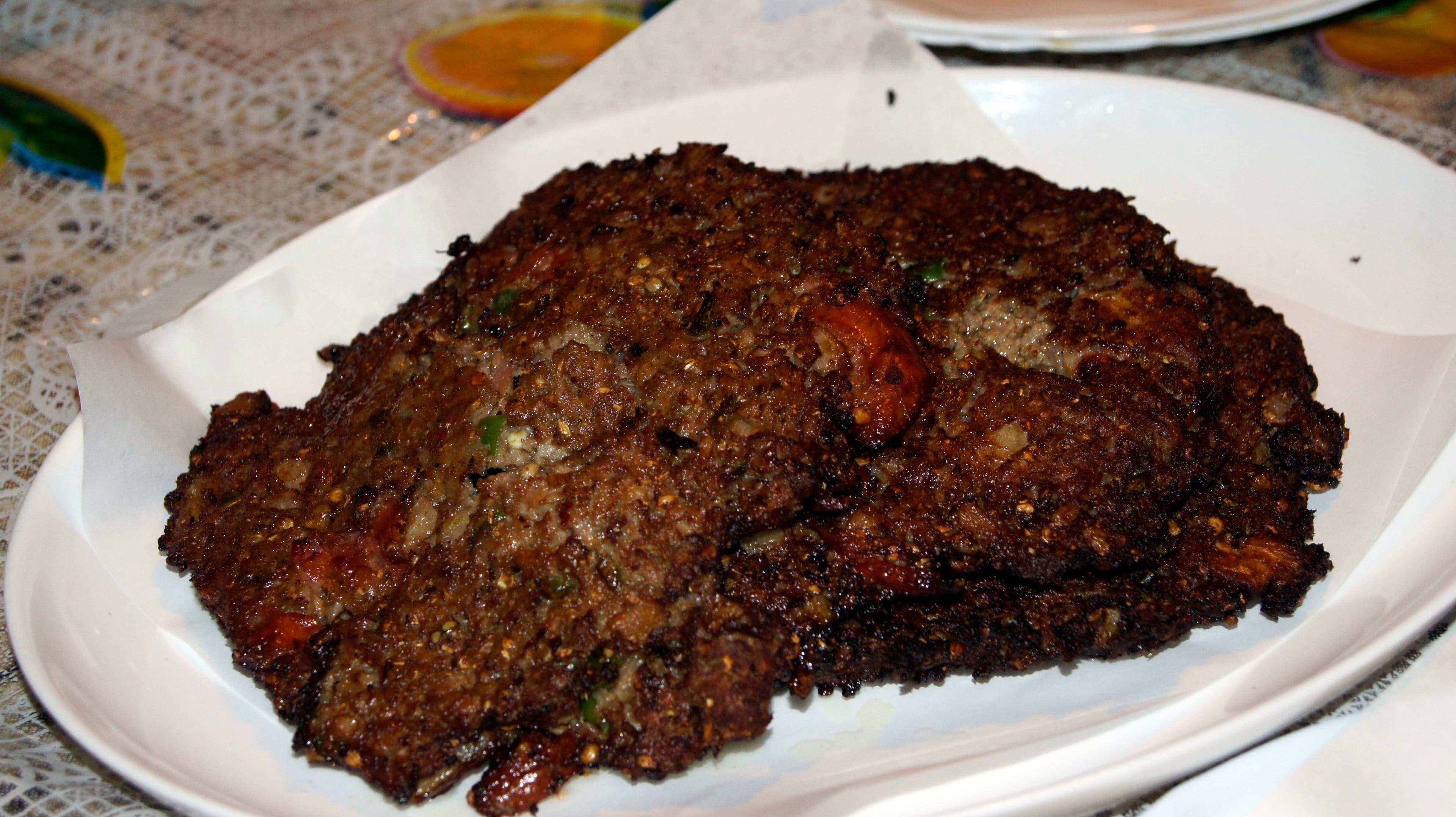 Chapli kebab patties frying in a pan, crisp and golden brown